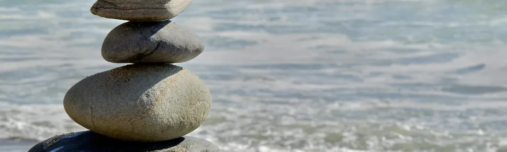 Sassi in equilibrio con la risacca del mare sullo sfondo