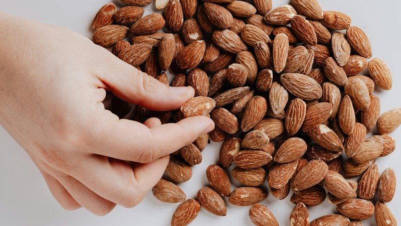 mano che prende tra le dita una madorla