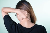 donna vista da dietro che si massaggia il collo